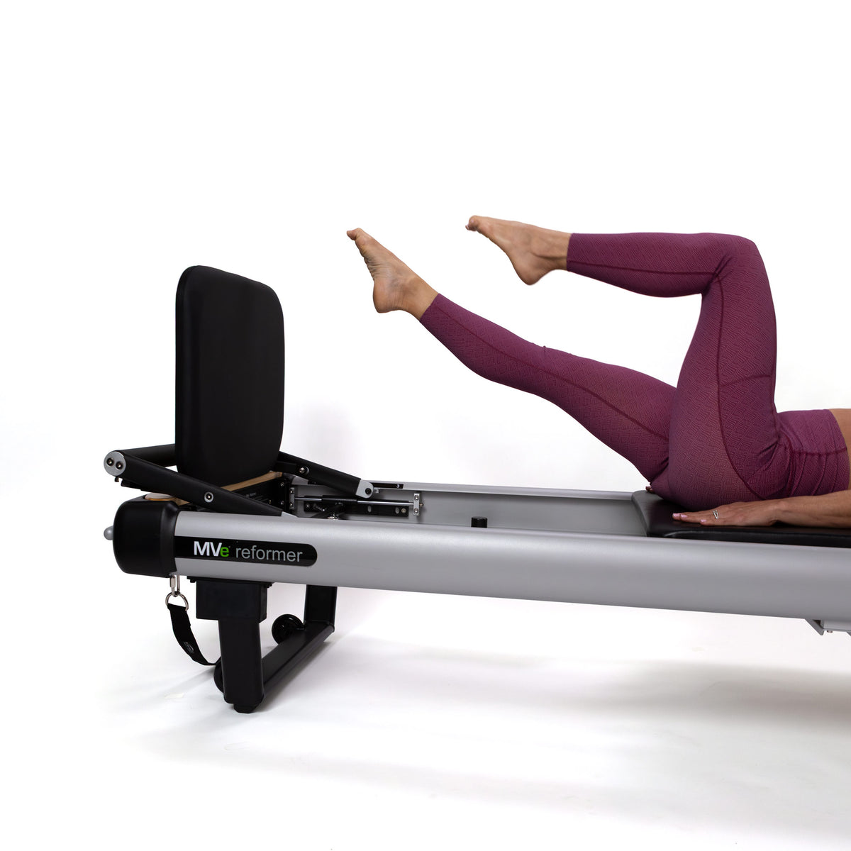 Person using a Peak Pilates MVe reformer, on a white background