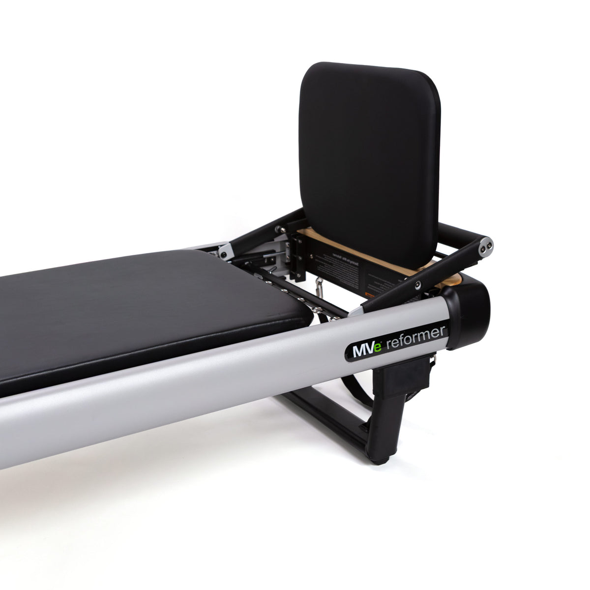 Close-up of a Peak Pilates MVe reformer showing the black padded footrest, backrest, metal frame on a white background.