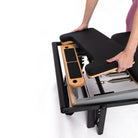 Person adjusting a footplate extender on a casa reformer