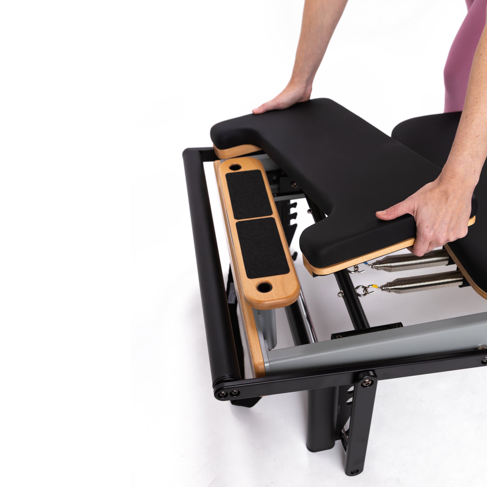 Person adjusting a footplate extender on a casa reformer